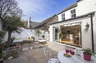 an outdoor patio with a couch and a table at Hideaway Tremayne in St Ives