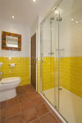 a bathroom with a toilet and a glass shower at Hideaway Tremayne in St Ives