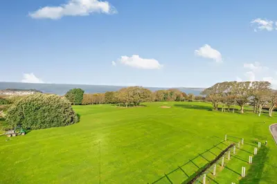 a large green field with trees and a fence at 3 Bed in St. Ives oc-l26941 in Carbis Bay