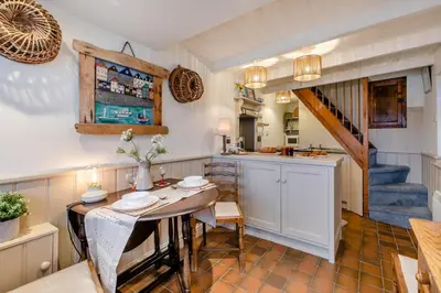 a kitchen and dining room with a table and a staircase at 1 Bed in St Ives oc-lhse in St Ives