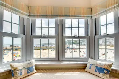 a room with three windows with a view of the beach at 1 Bed in St Ives oc-lhse in St Ives