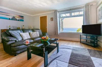 a living room with a leather couch and a large window at 2 Bed in St Ives oc-lookcv in St Ives