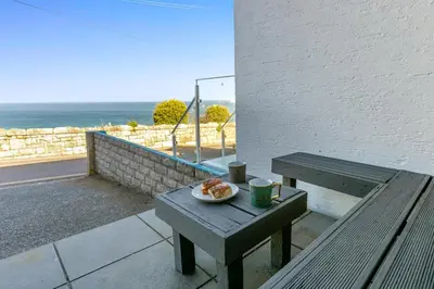 a picnic table with a plate of food on a balcony at 2 Bed in St Ives oc-lookcv in St Ives
