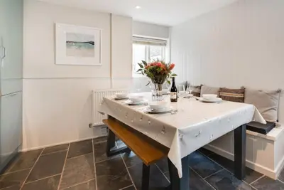 a dining room with a table with a vase of flowers at 3 Bed in St. Ives oc-marhou in St Ives