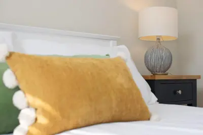 a bed with a pillow and a lamp on a table at 3 Bed in St. Ives oc-marhou in St Ives