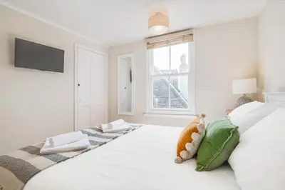 a white bedroom with a large bed with a window at 3 Bed in St. Ives oc-marhou in St Ives