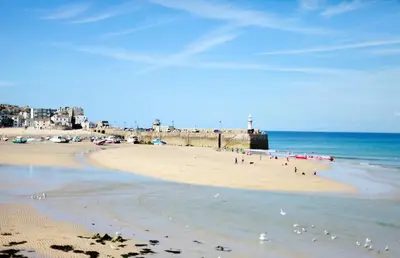 a group of people on a beach with the ocean at 2 Bed in St. Ives oc-minmar in St Ives