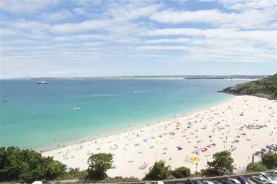 a beach with a lot of people in the water at 2 Bed in St. Ives oc-minmar in St Ives