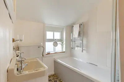 a white bathroom with a tub and a sink at 2 Bed in St. Ives oc-minmar in St Ives