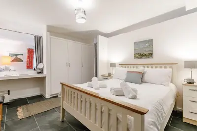 a bedroom with a large white bed and a desk at 1 Bed in St Ives oc-nic01 in St Ives