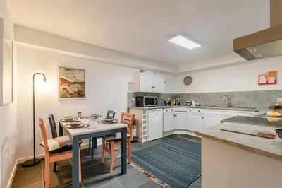 a kitchen with a table and chairs and a kitchen with white cabinets at 1 Bed in St Ives oc-nic01 in St Ives