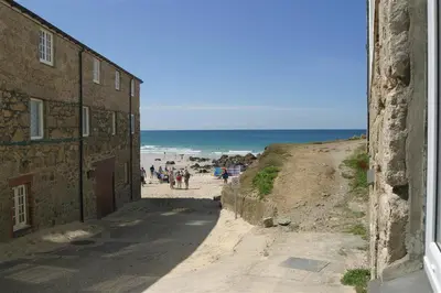 a group of people on a beach next to a building at 1 Bed in St Ives oc-nic01 in St Ives