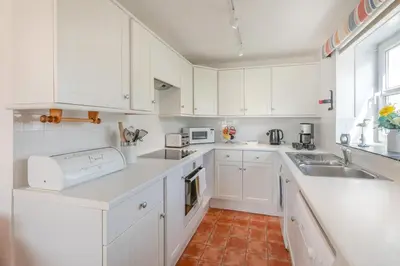 a white kitchen with white cabinets and a sink at 2 Bed in St Ives oc-nic24 in St Ives