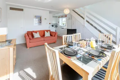 a dining room with a table and chairs and a couch at 2 Bed in St Ives oc-nic24 in St Ives