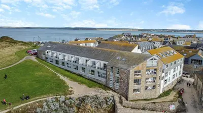 an aerial view of a building with the ocean in the background at 2 Bed in St Ives oc-nic24 in St Ives