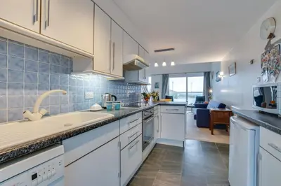 a kitchen with white cabinets and a living room at 1 Bed in St Ives oc-nicc41 in St Ives