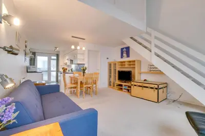 a living room with a blue couch and a kitchen at 1 Bed in St Ives oc-nicc41 in St Ives