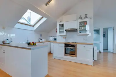 a large kitchen with white cabinets and a window at 1 Bed in St Ives oc-nic48 in St Ives