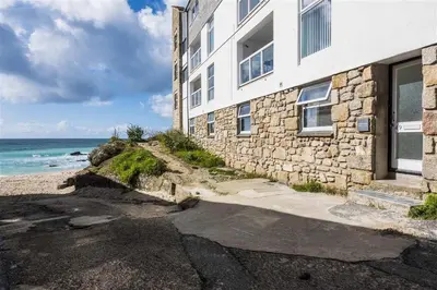a stone building next to a beach with the ocean at 1 Bed in St Ives oc-nic049 in St Ives