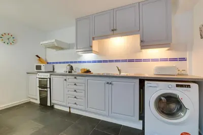 a kitchen with white cabinets and a washing machine at 1 Bed in St Ives oc-nic049 in St Ives