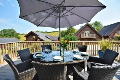 a table with an umbrella on a deck at 4 Bed in Wadebridge oc-p00066 in Little Petherick