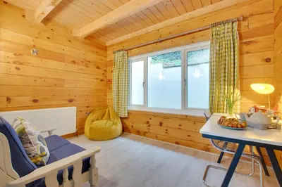 a log cabin with a table and a window at 4 Bed in Wadebridge oc-p00066 in Little Petherick