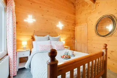 a bedroom with a bed in a log cabin at 4 Bed in Wadebridge oc-p00066 in Little Petherick