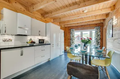 a kitchen with white cabinets and a table and chairs at 4 Bed in Wadebridge oc-p00066 in Little Petherick