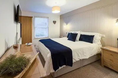 a bedroom with a large bed with blue pillows at 2 Bed in St Ives oc-pedtc1 in St Ives