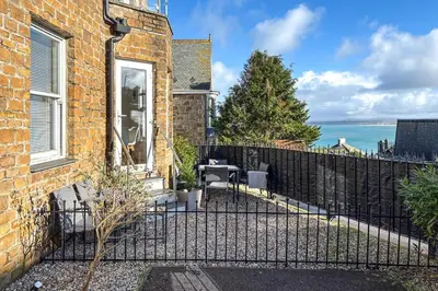 a fence in front of a house with a view of the ocean at 2 Bed in St Ives oc-pedtc1 in St Ives