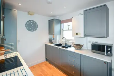 a kitchen with blue cabinets and a clock on the wall at 2 Bed in St Ives oc-pedtc1 in St Ives