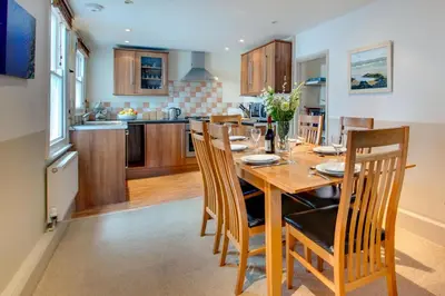 a kitchen and dining room with a wooden table and chairs at 2 Bed in St Ives oc-pmho08 in St Ives