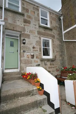 a house with a white fence and flowers in front of it at 2 Bed in St Ives oc-pmho08 in St Ives