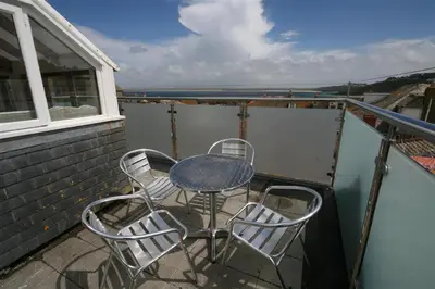 a table and chairs on a balcony with a view of the water at 2 Bed in St Ives oc-pmho10 in St Ives