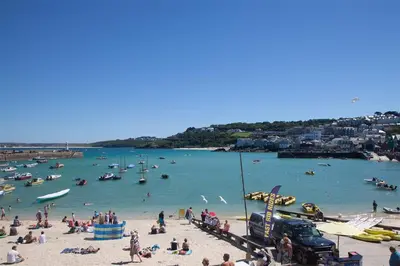people on a beach with boats in the water at 1 Bed in St Ives oc-quayst in St Ives