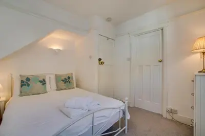 a bedroom with a bed with white sheets and a lamp at 1 Bed in St Ives oc-quayst in St Ives