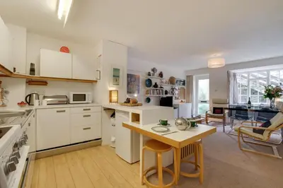 a kitchen with white cabinets and a table with chairs at 2 Bed in St Ives oc-redc4 in St Ives