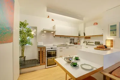 a large kitchen with white cabinets and a table at 2 Bed in St Ives oc-redc4 in St Ives