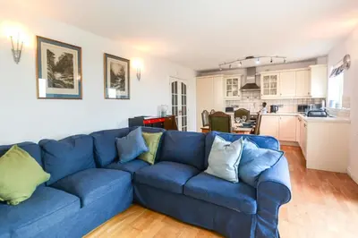 a blue couch in a living room with a kitchen at 3 Bed in Porthleven oc-rosen in St Ives