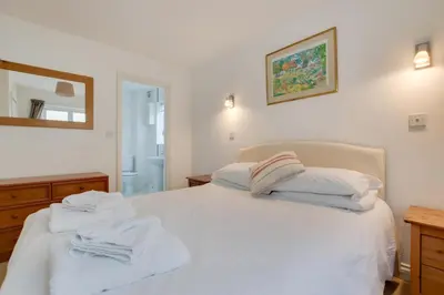 a bedroom with a white bed with towels on it at 3 Bed in Porthleven oc-rosen in St Ives