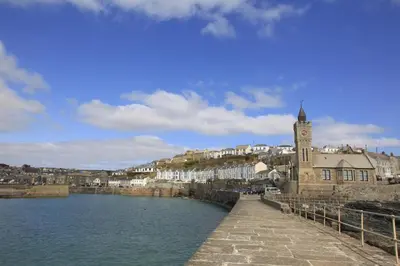 a town with a clock tower next to a body of water at 3 Bed in Porthleven oc-rosen in St Ives