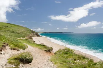 a sandy beach next to the ocean on a hill at 3 Bed in Porthleven oc-rosen in St Ives