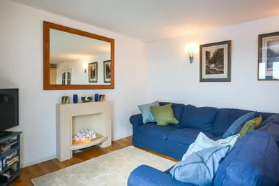 a living room with a blue couch and a mirror at 3 Bed in Porthleven oc-rosen in St Ives
