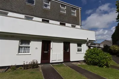 a white house with two doors and a balcony at 1 Bed in St Ives oc-seacft in St Ives
