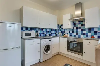 a kitchen with white cabinets and a washer and dryer at 1 Bed in St Ives oc-seacft in St Ives