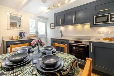 a kitchen with a table with black cabinets at 2 Bed in St Ives oc-shell in St Ives
