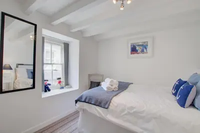 a white bedroom with a bed and a mirror at 2 Bed in St Ives oc-stg019 in St Ives