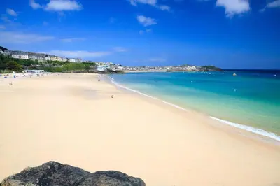 a beach with people swimming in the ocean at 2 Bed in St Ives oc-stg019 in St Ives