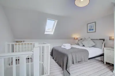 a white bedroom with a bed and a window at 2 Bed in St Ives oc-stg019 in St Ives