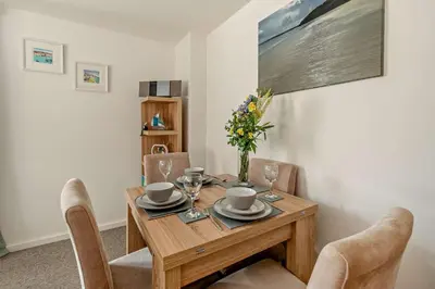 a wooden table with chairs and a vase of flowers at 2 Bed in Carbis Bay oc-t27418 in Carbis Bay